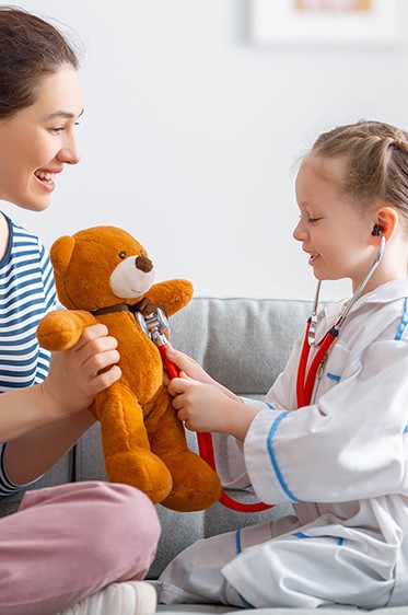 little girl playing doctor with her mother