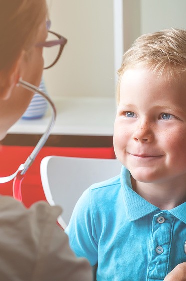 pediatrician with child patient listening to their heart