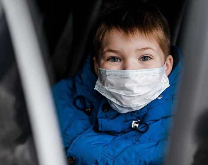 child wearing medical mask in car