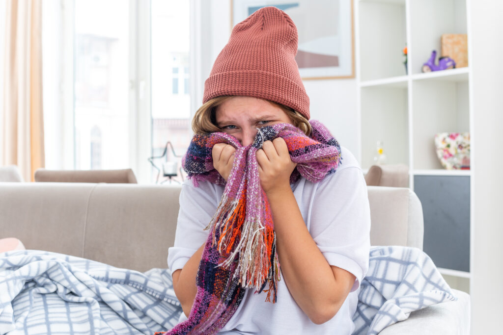 young man wearing a scarf sitting on his couch